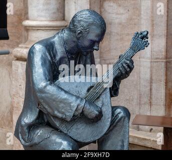 Ein Bild einer Skulptur, die einen portugiesischen Gitarristen zeigt, der das traditionelle Genre der Fado-Musik Portugals (Lissabon) repräsentiert. Stockfoto