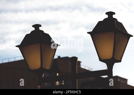 Stadtlichter in einem öffentlichen Park in der Abenddämmerung aus nächster Nähe. Stockfoto