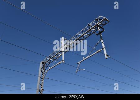 Eisenbahn-Hochspannungs-Mast gegen blauen Himmel, Großbritannien Stockfoto