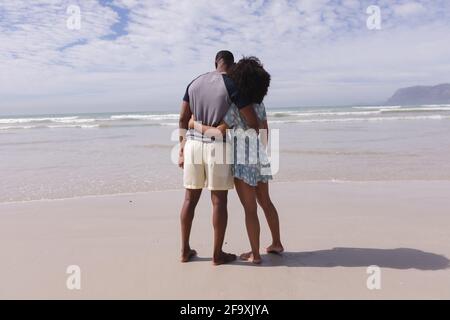 afroamerikanisches Paar, das am Strand steht und umarmt Stockfoto