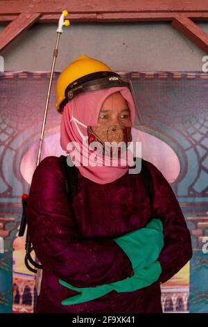 Padang, Indonesien, 21. April 2021. Frauen in Indonesien, Padang City, Provinz West-Sumatra tragen den Kebaya zum Kartini-Tag und sprühen Desinfektionsmittel auf öffentlichen Straßen im Dorf Batang Arau. Kariadil Harefa. Stockfoto