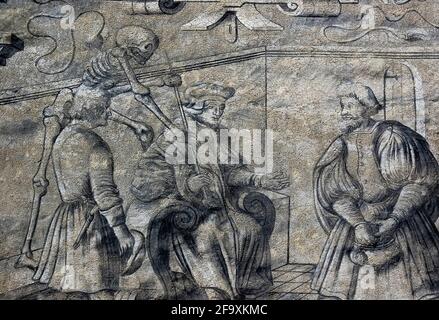 Ein Skelett, das den Tod symbolisiert, ergreift den Stab eines Richters, das Symbol seiner Macht, um ihn zu brechen, während die Aufmerksamkeit des Richters von einem armen Mann neben ihm zu einem reichen Mann wechselt, der nach Geld greift, um ihn zu bestechen, In diesem Detail eines Chiaroscuro-Gemäldes von Jan Březnický aus dem Jahr 1571 auf der façade des Alten Rathauses in Prachatice, Südböhmen, Tschechien / Tschechien. Inspiriert wurde das Kunstwerk von „The Judge“, einem der beunruhigenden Holzschnitte im Zyklus „Tanz des Todes“ des deutschen Künstlers Hans Holbein dem Jüngeren (1497-1543), in dem Menschen aller Gesellschaftsschichten mit ihrer eigenen Sterblichkeit konfrontiert werden. Stockfoto