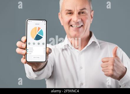 Leitender Geschäftsmann mit Grafiken und Diagrammen auf dem Bildschirm Stockfoto