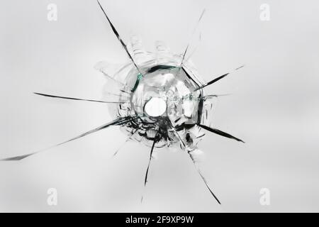 Die Textur des Lochs aus dem Schuss auf das Glas. Kaputtes Fenster. Stockfoto