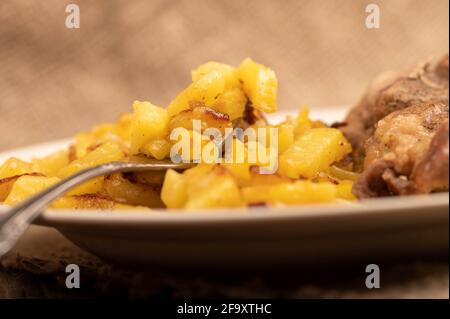 Hausgemachte Bratkartoffeln und ein großes Stück Fleisch auf einem weißen Teller.Nahaufnahme. Stockfoto