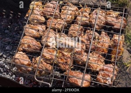 Blick von oben auf saftiges Schweinefleisch, das im Freien auf Schwelbrand gegrillt wird Kohlenstoffe Stockfoto