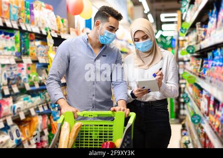 Muslimisches Paar Nimmt Notizen In Der Liste Kauf Von Lebensmitteln Im Supermarkt Stockfoto