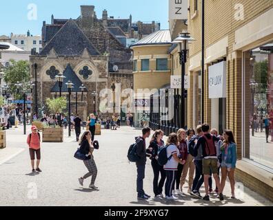 Staycation Idee. An einem sonnigen Sommertag steht eine Gruppe junger Menschen draußen im Einkaufszentrum Priory Meadow in Hastings. Rathaus Von Hastings. Stockfoto