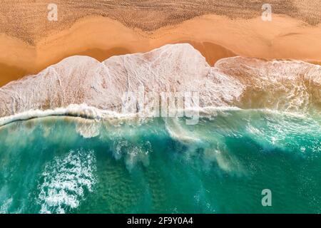Luftaufnahme des atlantischen Ozeans Sandstrand mit brechenden Wellen. Blick von oben auf die Küste mit türkisfarbenem Wasser Stockfoto