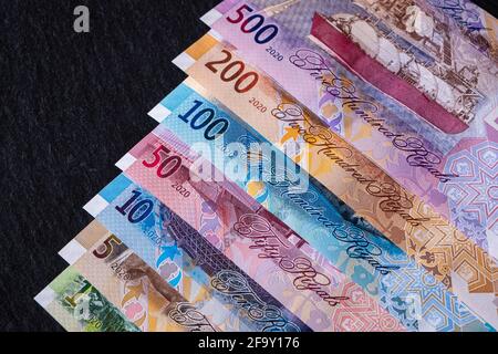 Neue katarische Riyal-Banknoten auf schwarzem Hintergrund Stockfoto