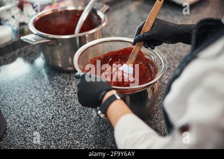 Der erfahrene Konditor bereitet in der Küche süße Füllung zu Stockfoto