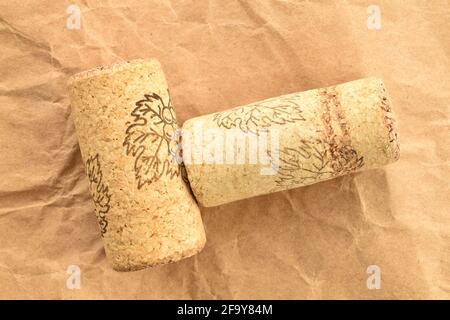 Zwei hellbraune Weinkorken auf Bastelpapier, Nahaufnahme, Draufsicht. Stockfoto