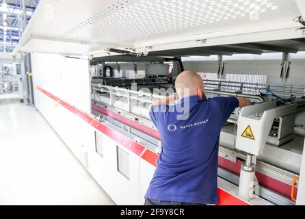 Freiberg, Deutschland. April 2021. Ein Mitarbeiter richtet die 12 Meter langen Laminatoren am neuen Hauptsitz des Solarmodulherstellers Meyer Burger ein. Die Anlage soll hier ab dem 26. Mai offiziell eröffnet werden. Das ist fast genau zehn Jahre nach der Eröffnung der SolarWorld. Derzeit werden Maschinen installiert und Produktionslinien vorbereitet. Das Schweizer Unternehmen hatte im vergangenen Jahr die Anlage des bankrotten Solarmodulherstellers SolarWorld in Freiberg übernommen. Quelle: Jan Woitas/dpa-Zentralbild/ZB/dpa/Alamy Live News Stockfoto