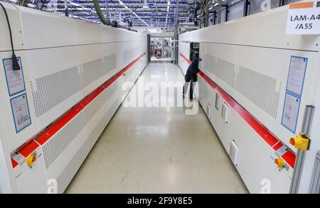 Freiberg, Deutschland. April 2021. Ein Mitarbeiter richtet die 12 Meter langen Laminatoren am neuen Hauptsitz des Solarmodulherstellers Meyer Burger ein. Die Anlage soll hier ab dem 26. Mai offiziell eröffnet werden. Das ist fast genau zehn Jahre nach der Eröffnung der SolarWorld. Derzeit werden Maschinen installiert und Produktionslinien vorbereitet. Das Schweizer Unternehmen hatte im vergangenen Jahr die Anlage des bankrotten Solarmodulherstellers SolarWorld in Freiberg übernommen. Quelle: Jan Woitas/dpa-Zentralbild/ZB/dpa/Alamy Live News Stockfoto