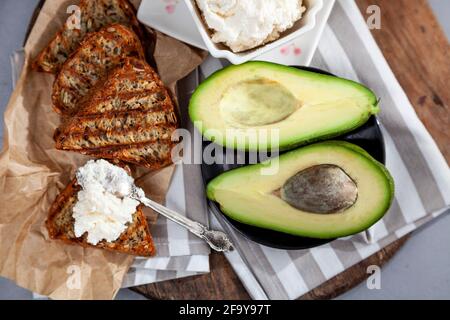 Sandwiches mit Weichkäse, Avocado und Gurke. Frühstück ist auf dem Tisch. Gesunde Ernährung. Toasten und darauf verteilen. Avocado Sandwich Stillleben Stockfoto