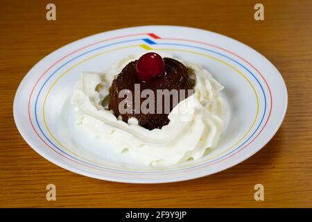 Creme Karamell Dessert oder Kaffee Flan mit Schlagsahne, eine Kirsche auf einem Teller und Holzhintergrund dekoriert Stockfoto