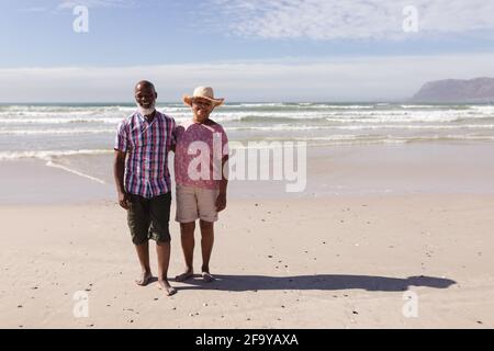 Porträt eines glücklichen älteren afroamerikanischen Paares, das auf dem steht Strand Stockfoto