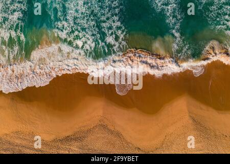 Aerial view of ocean waves and sandy beach. Top view of sea coast with turquoise water Stockfoto