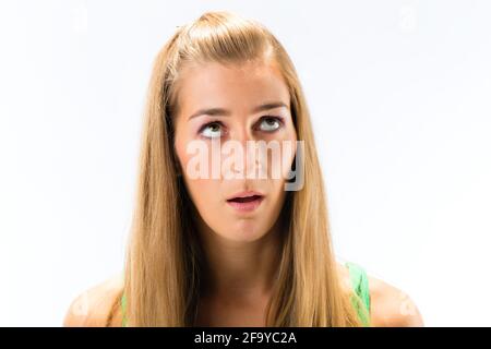 Nahaufnahme einer betrachteten jungen Frau vor weißem Hintergrund Stockfoto