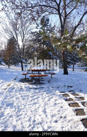 Gehweg zu Tisch und Bänken im Schnee Stockfoto