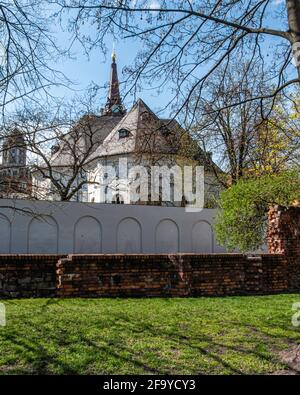 Die Pfarrkirche und die mittelalterliche Stadtmauer-Ruine in Mitte, Berlin, Deutschland. Älteste evangelische Kirche & historische alte Backstein- und Steinmauer Stockfoto