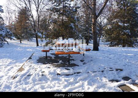 Gehweg zu Tisch und Bänken im Schnee Stockfoto