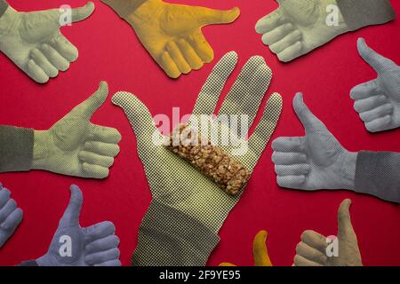 Proteinriegel auf bedruckter Hand mit aufgedruckter Geste nach oben. Stockfoto