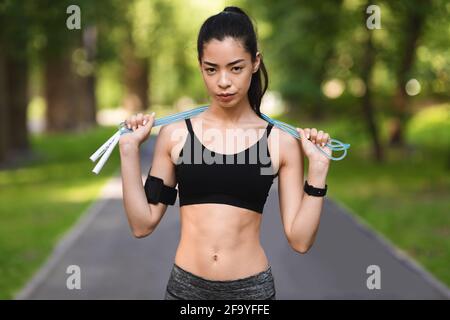 Motivierte Fit Asiatische Frau Posiert Mit Springseil Im Freien, Training Im Park Stockfoto