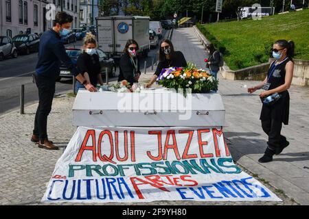 Lissabon, Portugal. April 2021. Bei einer Trauerfeier vor dem Palast der Republikanischen Versammlung in Lissabon führen Menschen mit Schutzmasken in der Nähe eines Sarges einen Ehrenakt durch.die Gruppe "Vigília Cultura e Artes" führt einen Straßenprotest durch, um Mahnwache für alle Fachleute des Kultursektors zu halten, die zurückgelassen wurden Durch die wenigen von der portugiesischen Regierung im Angesicht der COVID-19-Pandemie programmierten Notfallmaßnahmen. (Foto von Jorge Castellanos/SOPA Images/Sipa USA) Quelle: SIPA USA/Alamy Live News Stockfoto