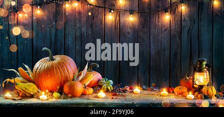 Thanksgiving - Kürbisse Auf Rustikalem Tisch Mit Kerzen Und Schnur Leuchtet Stockfoto
