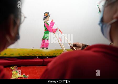 Shahe, Chinas Provinz Hebei. April 2021. Ein Schüler spielt mit einer Schattenpuppe an der Mittelschule Nr. 6 in der Stadt Shahe, nordchinesische Provinz Hebei, 21. April 2021. Die Mittelschule hat lokale Künstler eingeladen, den Schülern das traditionelle Schattenspiel vorzustellen, um ihre Schüler besser mit dem immateriellen Kulturerbe vertraut zu machen. Quelle: Luo Xuefeng/Xinhua/Alamy Live News Stockfoto