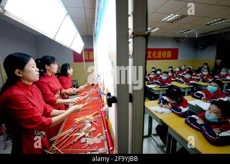 Shahe, Chinas Provinz Hebei. April 2021. Künstler führen ein Schattenpuppentheater für Schüler an der Mittelschule Nr. 6 in der Stadt Shahe, nordchinesische Provinz Hebei, am 21. April 2021 durch. Die Mittelschule hat lokale Künstler eingeladen, den Schülern das traditionelle Schattenspiel vorzustellen, um ihre Schüler besser mit dem immateriellen Kulturerbe vertraut zu machen. Quelle: Luo Xuefeng/Xinhua/Alamy Live News Stockfoto