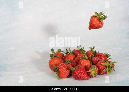 Levitation-Effekt, fallende Erdbeeren auf hellem Hintergrund Stockfoto