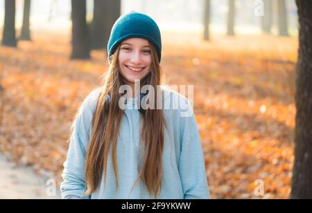 Lächelndes Mädchen mit Kopfhörern in der Natur Stockfoto