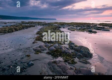 Peppercombe Beach bei Sonnenuntergang an der Küste von North Devon mit Hartland Point in der Ferne, England. Stockfoto