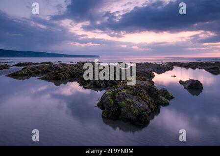 Peppercombe Strand in der Abenddämmerung an der Küste von North Devon mit Hartland Point in der Ferne, England. Stockfoto