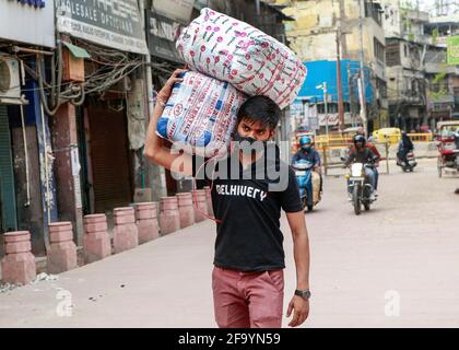 Neu-Delhi, Indien. April 2021. Ein Arbeiter sah, wie er Pakete auf dem Großhandelsmarkt in Chandni Chowk transportierte, wo die Geschäfte während der Sperrung durch die Regierung geschlossen bleiben. (Foto von Ganesh Chandra/SOPA Images/Sipa USA) Quelle: SIPA USA/Alamy Live News Stockfoto