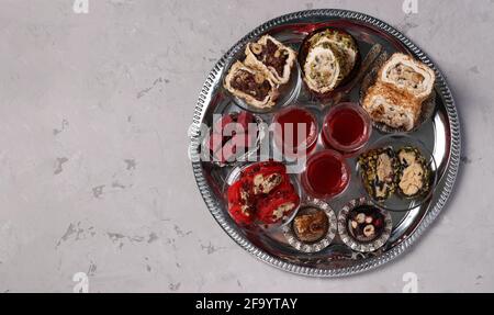 Teezeremonie mit einer Auswahl türkischer Süßigkeiten auf einem runden Metalltablett auf grauem Hintergrund. Blick von oben. Platz für Text Stockfoto