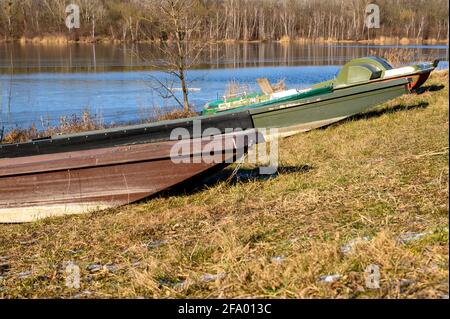 Einige verlassene kleine Fischerboote liegen am winterlichen Ufer der Donau. Stockfoto