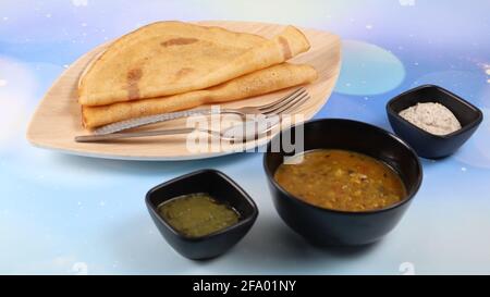 Dosa (Thin Pancake oder Crepe) ist eine südindische Mahlzeit, die mit sambhar und Kokosnuss-Chutney (Sauce) serviert wird, isoliert in einem anderen Hintergrund, einem anderen Stil Stockfoto