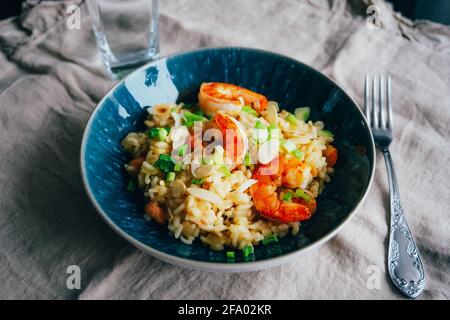 Hausgemachte Garnelenpaella auf blauem Teller serviert Stockfoto