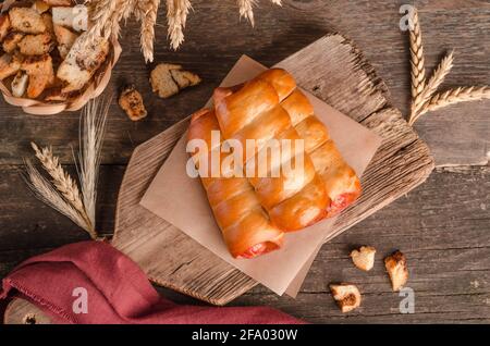 Appetitlich frisches kulinarisches Gebäck - Würste in Gebäck auf Holz Hintergrund Stockfoto