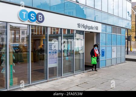 Eine Frau verlässt eine Zweigstelle der TSB-Bank in Archway, North Islington, London, Großbritannien Stockfoto