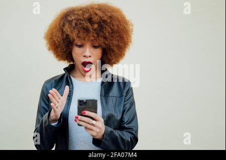 Überrascht afroamerikanische Frau mit Smartphone Stockfoto