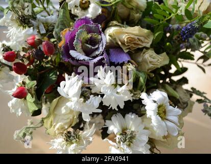 Verwelkt Bouquet von weißen Rosen und Chrysanthemen, lila Kohl und Grüns. Das Konzept des Endes eines Urlaubs oder einer Beziehung. Selektiver Fokus. Stockfoto