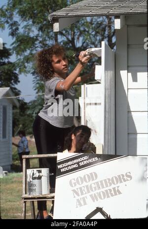 San Antonio, TX, USA: Freiwilliger aus der Mittelschule malt während eines von der Stadt gesponserten „Paint-a-thon“ das Haus eines Einwohners mit niedrigem Einkommen aus. ©Bob Daemmrich Stockfoto