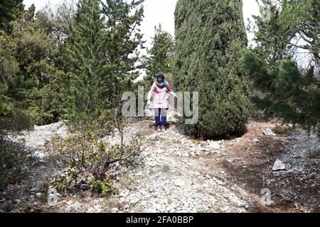 Die Frau steigt im Frühjahr vom Berg Balgatura herab Stockfoto