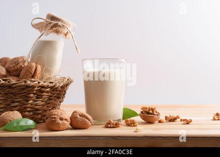 Glas alternative Gemüsegetränk Walnüsse mit Früchten auf dem Tisch mit Korb in einem Feld von Walnussbäumen. Stockfoto