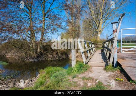 Kleine Fußgängerbrücke über den Schwarzen Graben / Bach (ein Nebenfluss des Flusses Arun) in der Nähe von Poling in Arundel, West Sussex, England, Großbritannien. Stockfoto