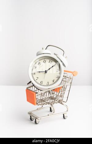 Ein Supermarkt-Trolley mit altem Vintage-Wecker. Stockfoto